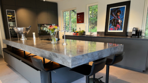 en köksö som ser ut att sväva i mitten av köket med corian lava rock som bänkskiva